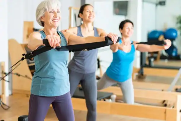 Toning Arms After 60: Empowering Womens Fitness Through Effective Weight Training 2 older woman doing weight training Tetbury and resistance in the gym to tone upper arms