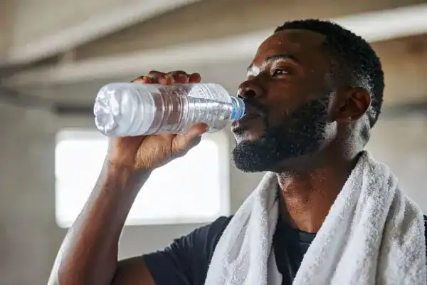 Hydration: The Secret Ingredient for a Toned Stomach and Enhanced Fitness 1 Image of man drinking water to improve hydration Tetbury after work out.